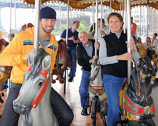 Troy Reinhart, left, 39, of Manhattan, and his parents Sandra Reinhart, right, 69, and Robert Reinhart, back right, 77, both of Girard, paid a visit to Jane’s Carousel at Brooklyn Bridge Park. The carousel, which reopened in New York on Sept. 16, was restored by Jane Walentas who purchased it in 1984 from Idora Park.