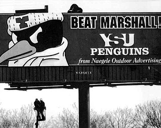 12/18/91 - Doug Oster.Go YSU: A billboard being erected at Martin Luther King Blvd. and the Madison Ave. freeway by Steve Savick of Niles, left, and Harmon Wolfe of Liberty both who work for Naegle Sign Company. The picture was shot from Rayen Ave. in Youngstown.