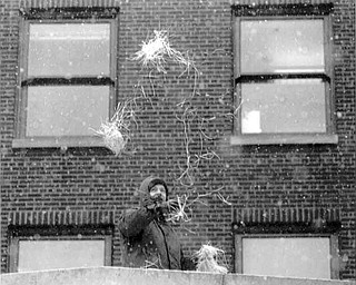 01/17/91 - Doug Oster.YSU PARADE: Kenneth Richards of Youngstown who works as a heating and air conditioning supervisor for Ohio One Corp. throws confetti off the roof of the Ohio One Building.