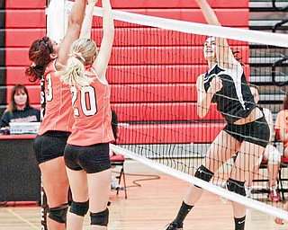 Girard player Bryanna Jay, 19, hits the ball as Springfield’s senior Brooke Schrieber, left, and sophomore Morgan Buchenic go up for the block. Girard rallied to win to the volleyball match.