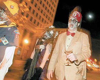 Dressed as zombies, Aidan, 10, Bailey, 13, and their father, John Hughes, of Niles, roamed Federal Plaza as part of the Zombie Crawl last year in downtown Youngstown.