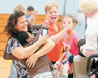 Joy DeCapita, substitute aide for Leonard Kirtz School, hugs Emani Martinez, 11, as they dance to Lady Gaga music during the school’s Harvest Carnival on Friday. More than 150 students and clients from the school and Bev Road and Meshel MASCO workshops attended the event.