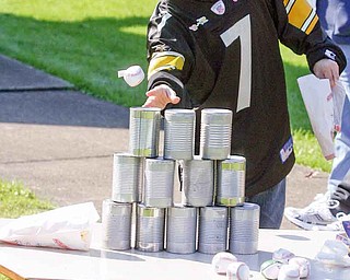 George Froble, 45, of Youngstown knocks over cans during the Harvest Carnival.