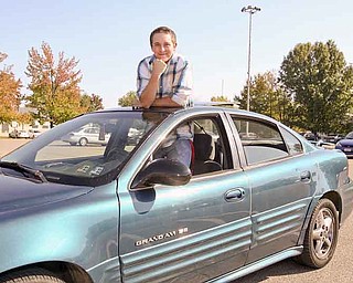 Charles Flesch, a student at Austintown Fitch High School, pokes out of the sunroof of his car. After attending 17 schools in four states, he’s confident he’s found a place he can call home.