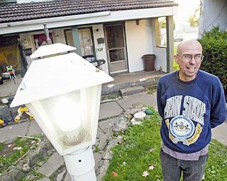 Tim Sokoloff of the Iron Soup Historical Preservation Co. stands near a solar-powered streetlight system at the former Sheet & Tube company housing area in Campbell. Sokoloff and his crew are working to create the world’s fi rst self-sustaining “Environminiums.”