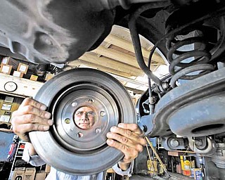 Bob Little, CEO of Ed Little Auto Service in Culver City, California, handles the rotor of a car receiving a brake job at his car repair shop on August 22, 2011. Many auto repair shops are flourishing in tough economic times for many Americans, according to industry statistics. (Mel Melcon/Los Angeles Times/MCT)