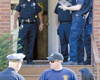 At right, Youngstown Police Lt. John Kelty, center, talks to witness Erica Haynes after she discovered the body of Tequon J. Sharpe, 20, of 59 E. Judson Ave., Saturday afternoon. Haynes told police a baby girl was also inside the house but unharmed.