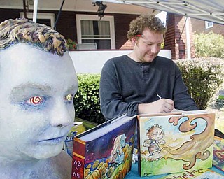 Jimmy Proctor, an artist from Springboro, Pa., creates custom covers for books. He was at Lawn-Con, a free comic book show, which took place Saturday in the Hartford Avenue front yard of local artist Chris Yambar.