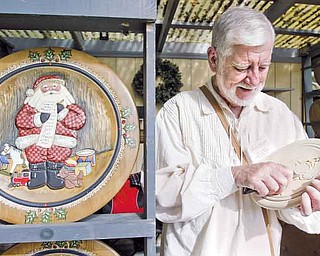 Woodcarver Don Lorigan of Kittanning, Pa., works on one of his hand carved and hand painted holiday plates at Christmas in the Woods festival.