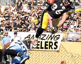 Pittsburgh Steelers receiver Hines Ward (86) heads to the end zone over Tennessee Titans safety Michael Griffin, scoring a touchdown during the third quarter of an NFL football game in Pittsburgh, Sunday, Oct. 9, 2011. (AP Photo/Gene J. Puskar)