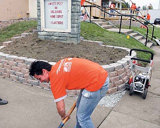 Emily Caroline of Boardman puts her back into her volunteer work during a Home Depot Foundation Celebration of Service project. Employees from the Boardman, Austintown, Niles and Salem Home Depot stores gathered at 305 Elm St. in Struthers Tuesday to help turn an old church building into a job assistance and training center for veterans. Approximately 85 employees volunteered their time.