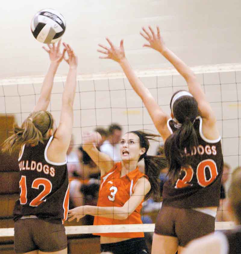 Mineral Ridge’s McKenzie Garland (3) spikes the ball against the defense of East Palestine’s Paige Peterson, left,
and Ashley Morris during Tuesday’s ITCL match.