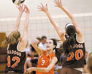 Mineral Ridge’s McKenzie Garland (3) spikes the ball against the defense of East Palestine’s Paige Peterson, left,
and Ashley Morris during Tuesday’s ITCL match.