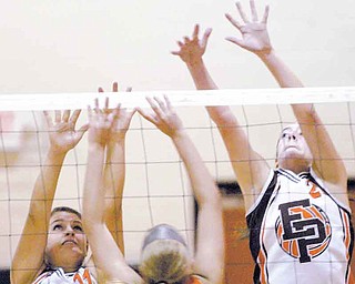 Mineral Ridge’s Alyssa Harkins (21) tries to get a shot past East Palestine’s Logan Gatchel, left, and Kae Huff during Tuesday’s volleyball match at Mineral Ridge.