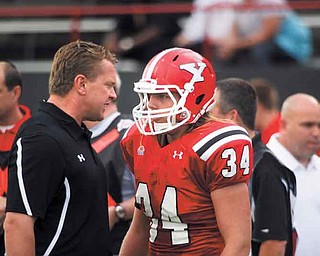 Youngstown State coach Eric Wolford talks to linebacker Thomas Sprague on the sideline during the Penguins’ game against Valparaiso on Sept. 10. After losing two straight games, Wolford said he’s not going to let his team settle for being average.