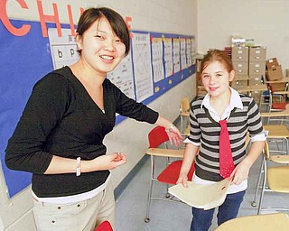 Zhen Zhen Li assists sixth-grader Jenna Kelvert with her work. Over the past five years, Hubbard school district has introduced both Chinese and Spanish to its elementary and middle school curricula.