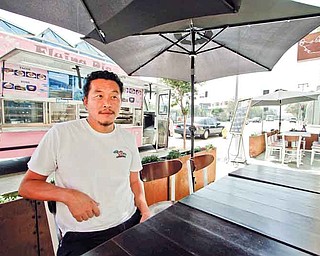 Owner Joe Kim sits at the outside table at the newly opened Flying Pig restaurant in Los Angeles, California, September 2, 2011. The Flying Pig food truck started out as a truck as a way for Kim to test out recipes before launching a restaurant. (Ricardo DeAratanha/Los Angeles Times/MCT)