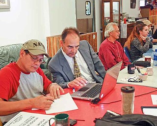 Members of Occupy Youngstown make plans at the Lemon Grove Café for a Saturday rally in downtown Youngstown. They are, from left, Rick Montanez of Lowellville, an unidentified man, Joseph Nestasie of Hillsville,
Pa., and Lauren Lenio of Boardman.