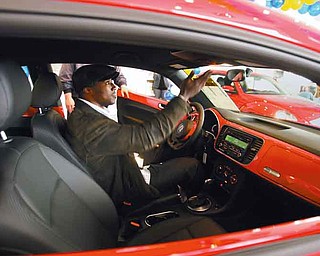 Deryck Toles of Warren checks out the 2012 Volkswagen Beetle 2.5L he picked up at Stadium Volkswagen in Boardman. He and Kimberly Winfrey of Warren were two of 275 audience members who received the prize during Oprah Winfrey’s “Ultimate Favorite Things” episode that aired in November 2010.