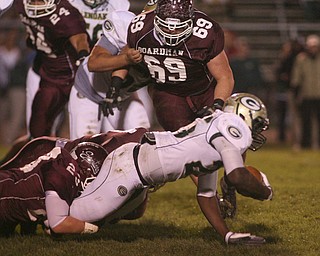 ROBERT K. YOSAY | THE VINDICATOR --..During first quarter action Glenoak #25 Brionte Dunn is stopped short of a first down by Boardmans #23 Dan Popio and #51 Zach Machuga (hidden) as Bdm #69 Zach Zidian watches --.Glen Oak vs Boardman at Boardman High School -..--30-..(AP Photo/The Vindicator, Robert K. Yosay)