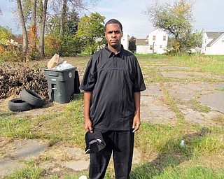 Roderick Lewis Jr. of Warren stands on the edge of a run-down park on Burton Street Southeast where he and others have been working recently to clean up. Lewis, 21, has been donating hundreds of dollars each year to a school-supplies giveaway and been involved in other community projects.