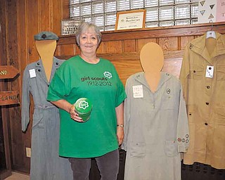 Trudee Davis of Austintown is historian of the Eastern Region of the Girl Scouts of North East Ohio. She’s displaying some of the Girl Scout uniforms she has collected, including ones from 1928 and 1919 at her left.