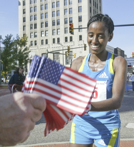 William D. Lewis|The Vindicator  Peace Race Sunday womens 1 rst place runner Mumis Eboka (check spelling). gets flag at end of race.