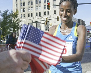 William D. Lewis|The Vindicator  Peace Race Sunday womens 1 rst place runner Mumis Eboka (check spelling). gets flag at end of race.