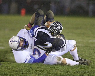 ROBERT  K.  YOSAY  | THE VINDICATOR --..Western Reserves #77   Aaron Halls - takes down McDonalds QB #2 Christian Rusinowski  for a 10 yard loss during second quarter action - Western Reserve Blue Devils ( white) vs McDonald Blue Devils at McDonald ..--30-..(AP Photo/The Vindicator, Robert K. Yosay)