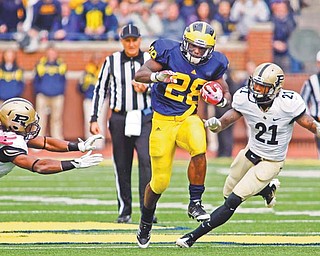Michigan running back Fitzgerald Toussaint (28), a graduate of Liberty High School, rushes away from Purdue defensive back Taylor Richards (4) and cornerback Ricardo Allen (21) for a touchdown in the third quarter of a game in Ann Arbor, Mich. Michigan won 36-14.