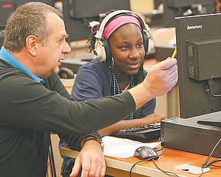 Gerald Wansack, a tutor at P. Ross Berry Eighth and Ninth Grade Academy in Youngstown, helps Johntaesia Allen, an eighth-grader, work through an algebra problem using a computer program.