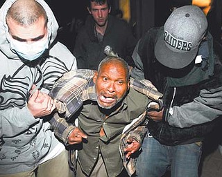 Protesters help an injured Occupy Oakland demonstrator after a police-fi red projectile struck his leg on Thursday.