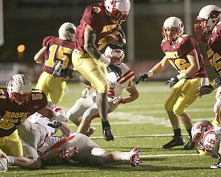 ROBERT K. YOSAY | THE VINDICATOR --..Mooneys #4 Marcus McWilson jumps over defenders as he takes the ball in for another Mooney Score Cardinal Mooney Cardinals vs Canal Fulton Northwest Indians at Stambaugh Stadium in the Regional Quarterfinals .--30-..(AP Photo/The Vindicator, Robert K. Yosay)