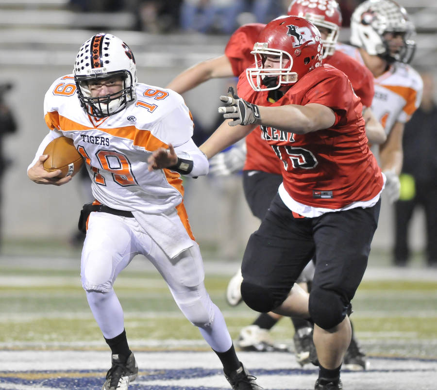 Howland quarterback #19 Eric Lockney scrambles away from Roosevelt defensivelinemen #75Austin Mastroine.