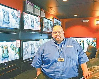Mark Worsencraf, the general manager of Aron’s Sales and Services, stands by a row of LCD TVs. Since opening in the Austintown Plaza in June, the retail store has donated $5,000 to local charities and community groups.