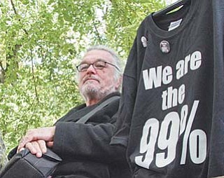 Walter Lichtenberg sits on a park bench selling shirts and buttons at the Occupy Portland camp in downtown Portland, Ore.