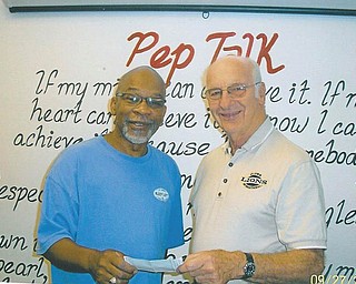 Helping kids go to camp: Youngstown Lions Club member Bill Cooper, right, presents a check to Dennis Griffin of The Needle’s Eye, a nonprofit organization and Christian counseling center in Youngstown. The donation will sponsor 40 children to go to camp.