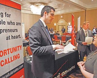 Blake Andrews, left, with Verizon, visits with prospective employees during a job fair in San Antonio. Employers advertised more jobs in September than at any other point in the past three years, a hopeful sign that the job market is slowly improving.