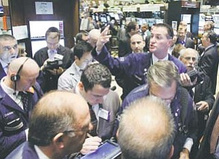 Trader Jonathan Corpina, right center, works on the fl oor of the New York Stock Exchange on Wednesday. The Dow Jones industrial average plunged 389 points Wednesday after Italy’s borrowing costs soared, a sign that Europe’s debt crisis had spilled into the third-largest economy in the euro bloc.