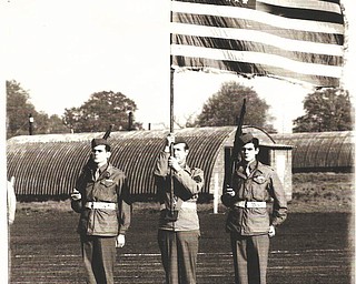 Leo Arnaut, left, and his identical twin brother, William, right, are pictured with a fellow soldier holding the flag. They joined the Army in 1942 and were discharged after both were shot while in the same fox hole during the D-Day invasion in France in 1944. Both received the Purple Heart. They were born and raised in Youngstown. Leo died in February 2010, and William, in March 1995. Leo's daughter, Colleen Joerndt, submitted the picture, adding that their family members are all very proud of them.