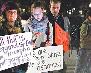 Penn State students stand outside the Old Main building on campus in State College, Pa., on Wednesday protesting the handling of a child abuse scandal involving retired Penn State assistant football coach Jerry Sandusky. PSU trustees fired head football coach Joe Paterno and university president Graham Spanier because they didn’t do enough to alert law enforcement authorities.