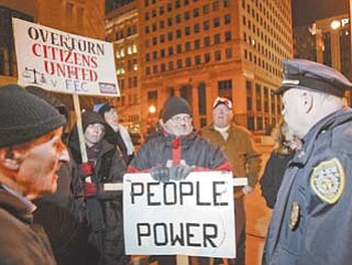 Youngstown police Capt. David McKnight speaks with Occupy Youngstown protesters Thursday night. An order from the police chief was given for the group to remove a tent and barrel from the protest site.