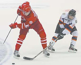 Phantoms defender Jordan Young (5) tries to keep the puck from the Fighting Saints’ Max Gardiner during Sunday’s game at the Covelli Centre. The Saints won 4-3.