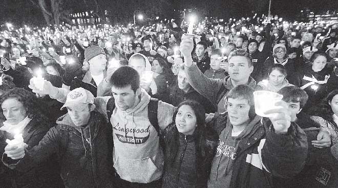 In this photo from Friday, people gather in front of the Old Main building for a candlelight vigil on the Penn State campus in State College, Pa., in support of the reported victims of a child-sex-abuse scandal involving a former assistant coach. As Penn State leaves a harrowing week behind and takes tentative steps toward a new normal, students and alumni wonder what exactly that means.