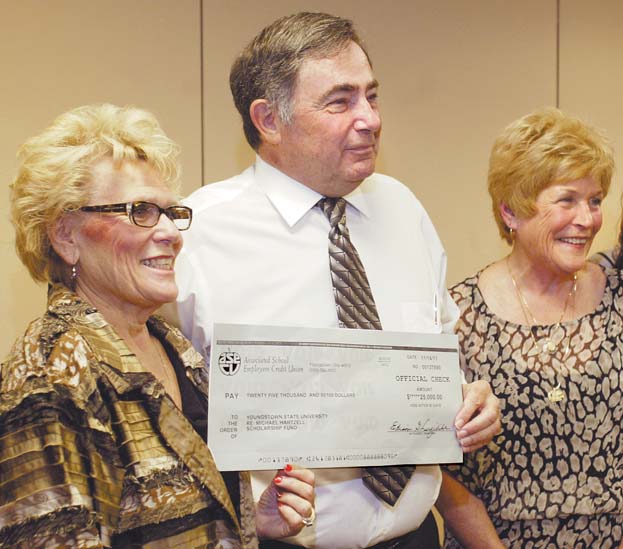 Howard and Mary Kay Hartzell present a $25,000 check to Youngstown State University President Cynthia Anderson, left, during a luncheon on campus. The Hartzells have raised $250,000 for scholarships in honor of their son, Youngstown Police Officer Michael Hartzell, who was killed in the line of duty in 2003. The presentation was Monday.