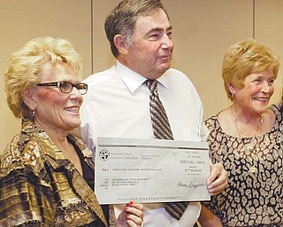 Howard and Mary Kay Hartzell present a $25,000 check to Youngstown State University President Cynthia Anderson, left, during a luncheon on campus. The Hartzells have raised $250,000 for scholarships in honor of their son, Youngstown Police Officer Michael Hartzell, who was killed in the line of duty in 2003. The presentation was Monday.