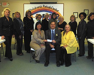 'Tutor U' gets a boost. Members of the Trumbull County Women's History Celebration Committee recently presented a $500 check to Executive Director Robert C. Foster of the Children's Rehabilitation Center for its "Tutor U" program. The program is designed to assist third-grade through eighth-grade youngsters who need extra academic help. Tutor U is offered from 4 to 7:30 p.m. Monday through Friday at the center, 885 Howland-Wilson Road NE, Howland. Call 330-856-2107, ext. 106, to set up a tutoring appointment. Standing, from left to right, are Julie Vugrinovich, Esther Gartland, Beky Davis, Theresa Salcone, Roz Jackson, Pam Hallett, Judie Hartley, Jo Anne Liptak, Kenya Howard and Stephanie Furano. Seated are Renee Maiorca, Foster and E. Carol Maxwell.