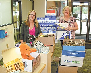 Glasses overflowing: The Boardman Lions Club made a donation of more than 1,400 pairs of used eyeglasses and 150 pairs of sunglasses to LensCrafters in the Boardman Plaza. September's donation was the largest single donation received at the branch. Above, Karen Kannal, right, Boardman Lions Sight Chairwoman, presents the glasses to Kayla Stone, LensCrafters licensed optician. Drop-off locations for eyeglasses include Boardman United Methodist Church, the Spectacle Spot, Boardman Library, St. Luke's Church, Boardman Center Middle School and Sam's Club. Stone says the eyeglasses are sent to Cincinnati for distribution to Mexico, Paraguay and India, among other countries.