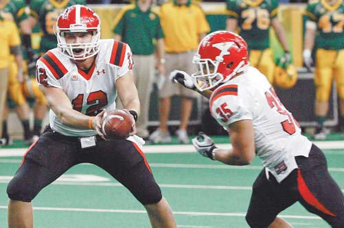 Youngstown State QB Kurt Hess (12) hands the ball to Jamaine Cook (35) during last Saturday’s win 27-24 win over North Dakota State University at the Fargodome in Fargo, N.D. On Saturday, the Penguins face Missouri  State, which is 1-9 and a team that YSU will not be taking lightly says Hess.