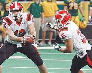 Youngstown State QB Kurt Hess (12) hands the ball to Jamaine Cook (35) during last Saturday’s win 27-24 win over North Dakota State University at the Fargodome in Fargo, N.D. On Saturday, the Penguins face Missouri State, which is 1-9 and a team that YSU will not be taking lightly says Hess.